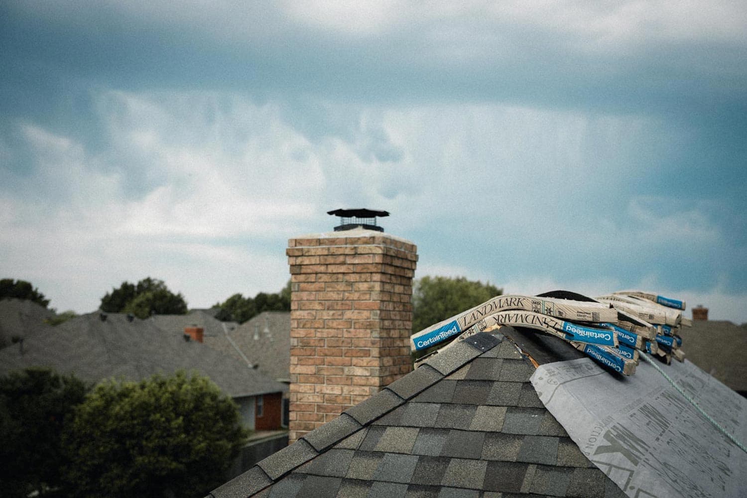 Roofing materials staged on an existing shingle roof in Fort Worth